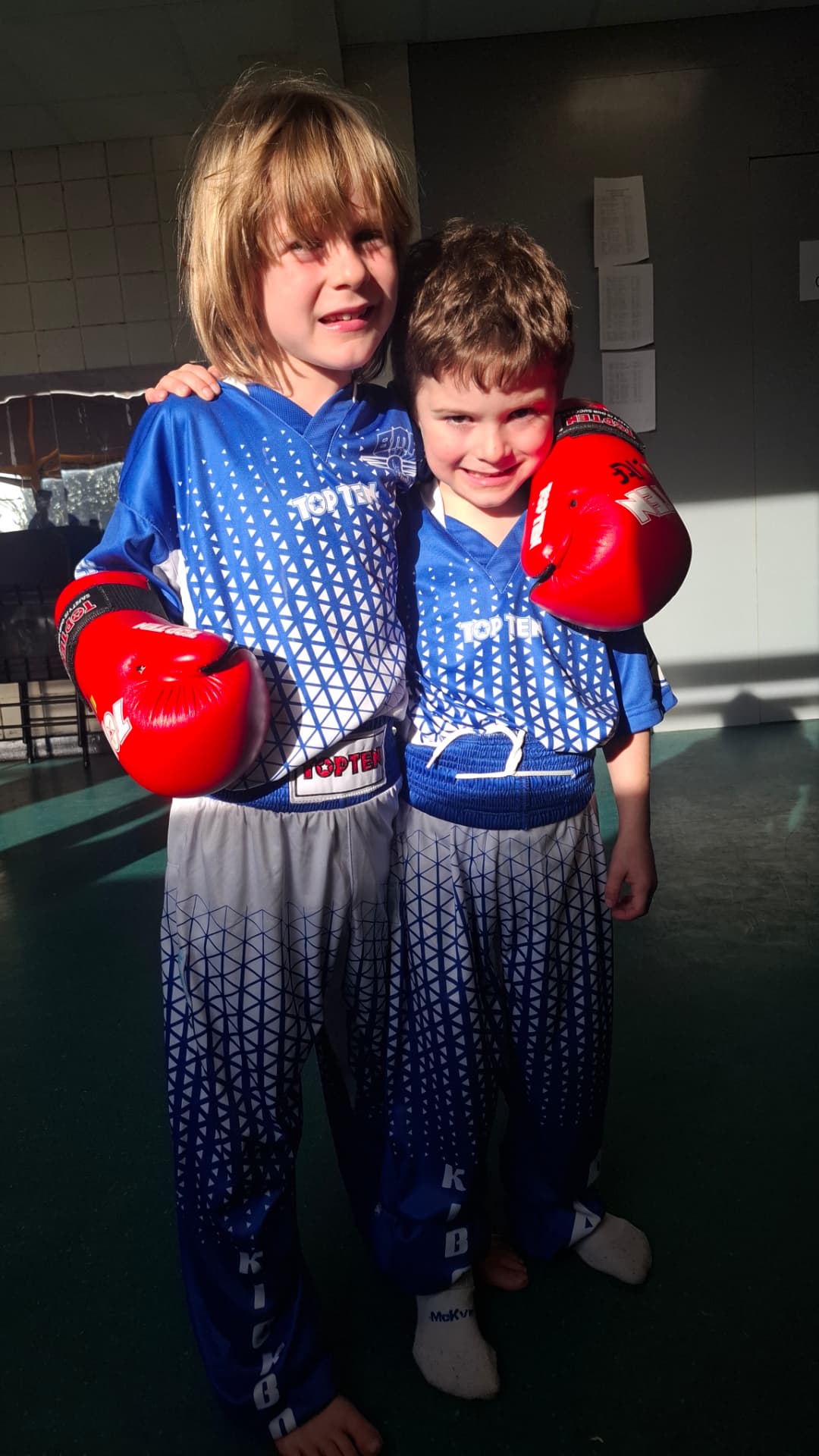 Two young BMA Southside members in red gloves, arm in arm
